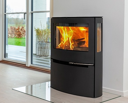 Minimalist wood burning stove with wide combustion chamber and side glass