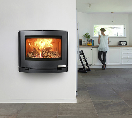 Wall mounted wood burning stove with broad view of the flames